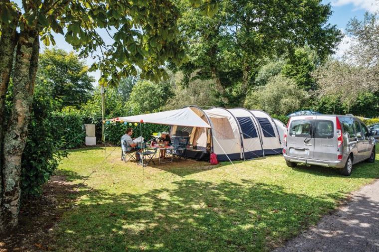 Emplacement caravaning spacieux avec place de parking intégrée.